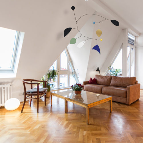 Mobile Calder Personnalisable Bleu Klein Vert Amande et Noir Dans Un Salon Sous Pente Avec Parquet | Virvoltan